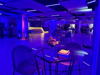 sala con mesas altas con iluminación violeta