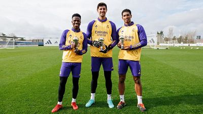 Vini Jr., Courtois and Bellingham pose with the FIFA FIFPro World11 trophies.